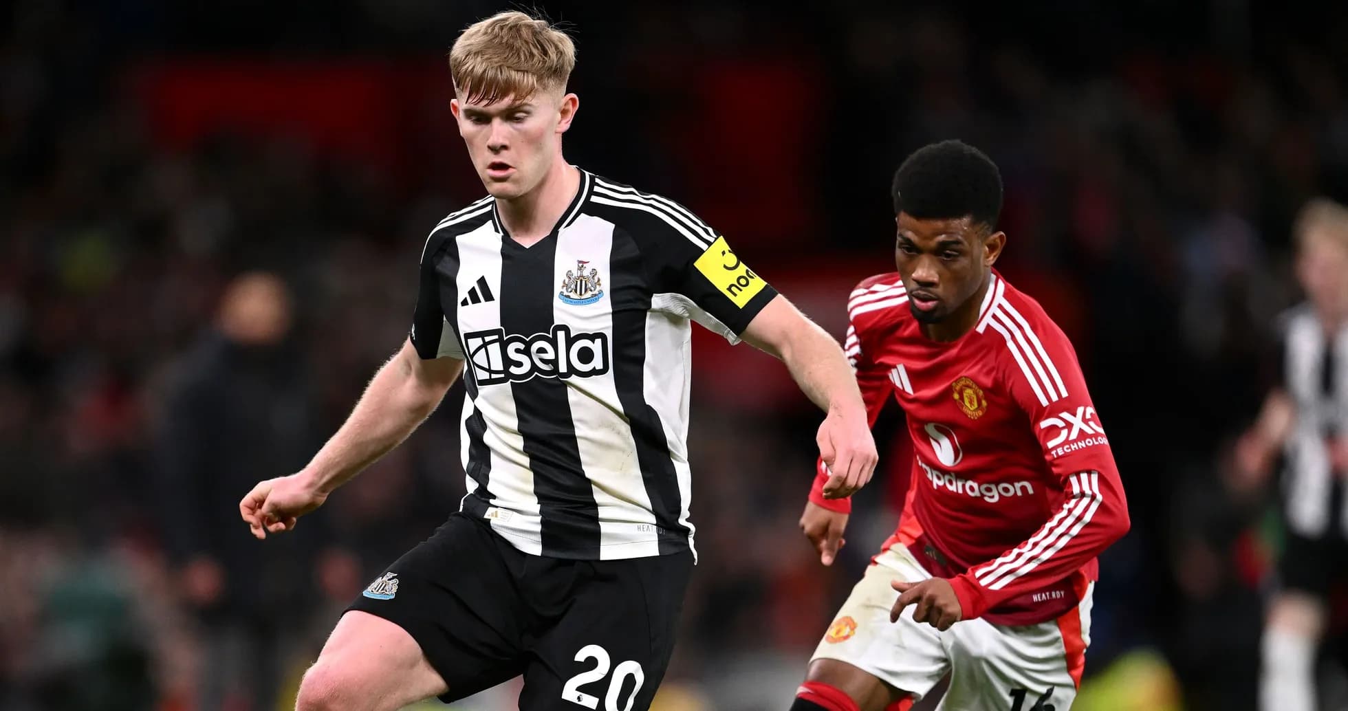 Newcastle player dribbling while Manchester United player defends