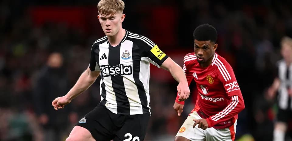 Newcastle player dribbling while Manchester United player defends