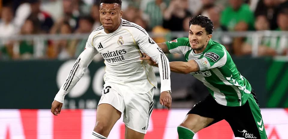 Mbappé sprinting with defender pulling his shirt