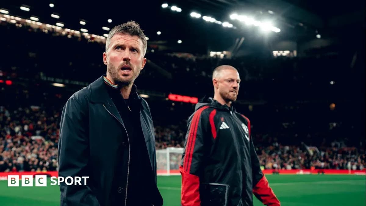 Two coaches walking on the pitch at Old Trafford