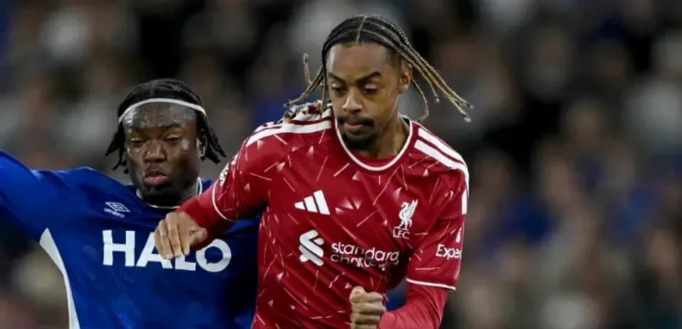 Player in red dribbling past opponent in blue