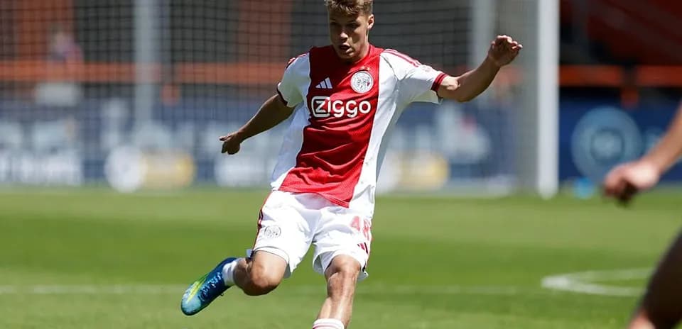Player in Ajax kit kicking the soccer ball