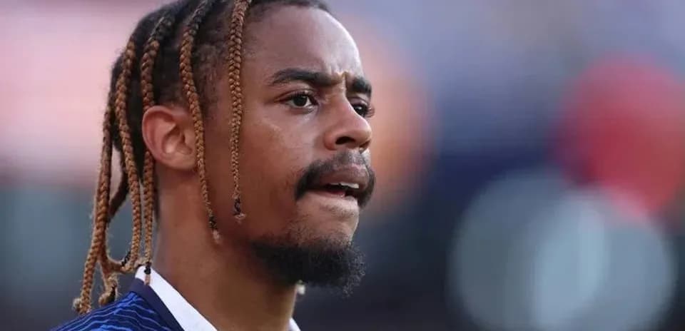 Player with braids focused during match preparation