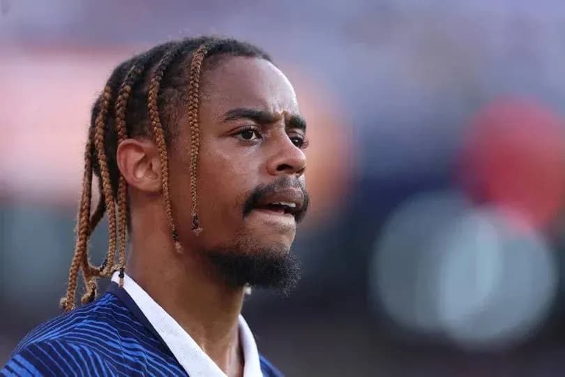 Player with braids focused during match preparation