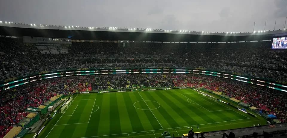 Crowd in stadium before match with green pitch