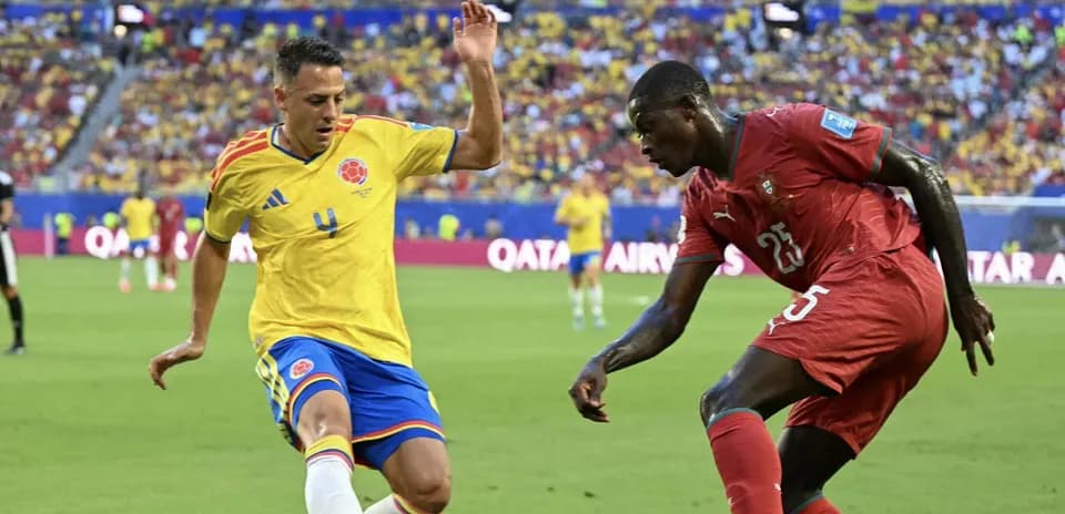 Colombian player challenges Moroccan player for the ball