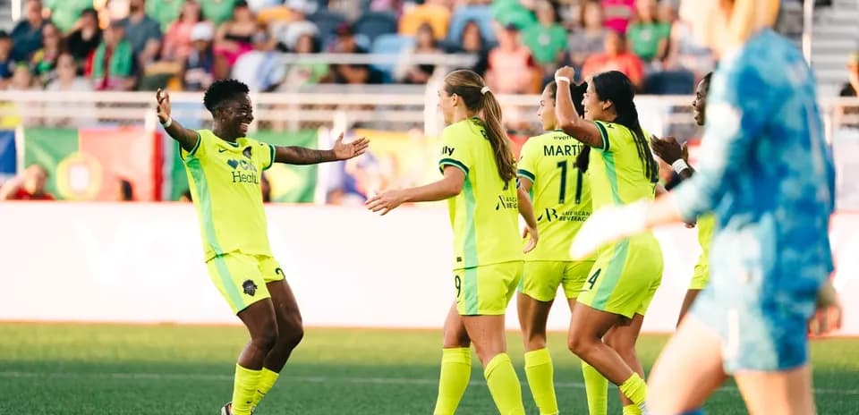 Players celebrating a goal during NWSL match