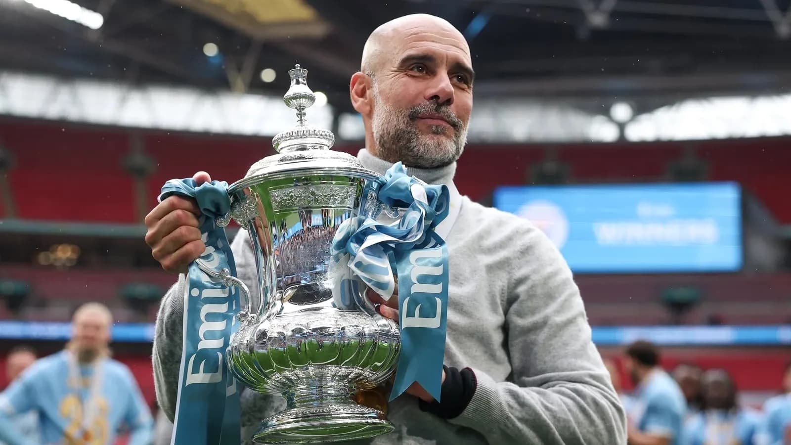 Coach holding trophy at stadium after victory