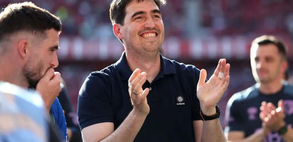 Man in polo shirt clapping with players nearby