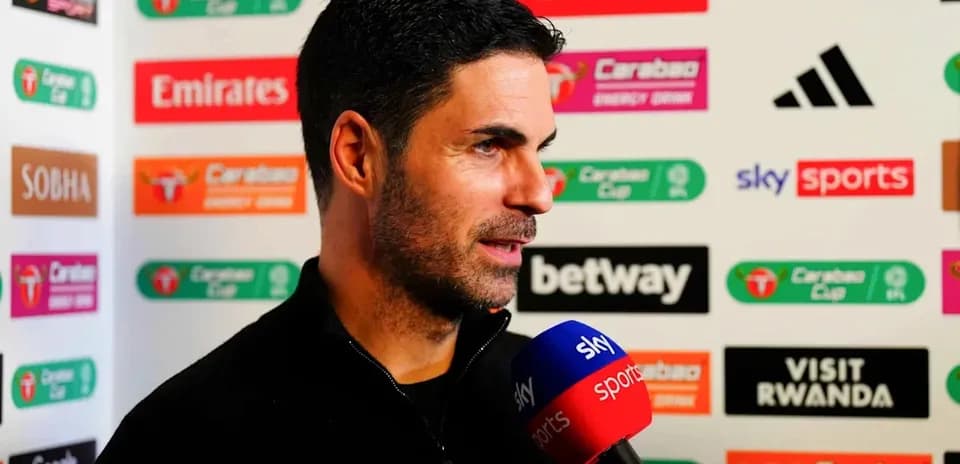 Manager speaking during a press conference with microphones