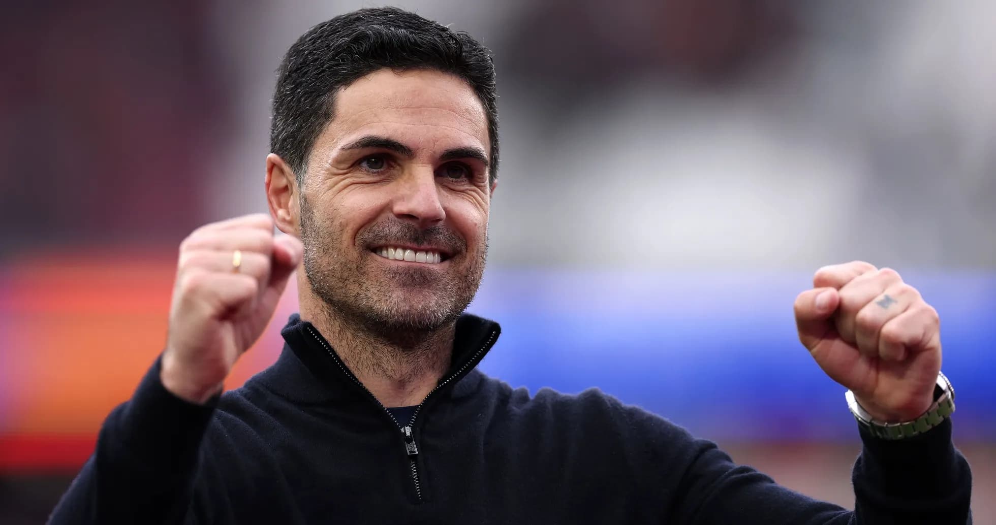 Coach celebrating with raised fists at stadium