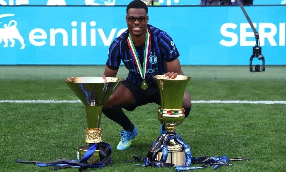 Player celebrating with two trophies on field