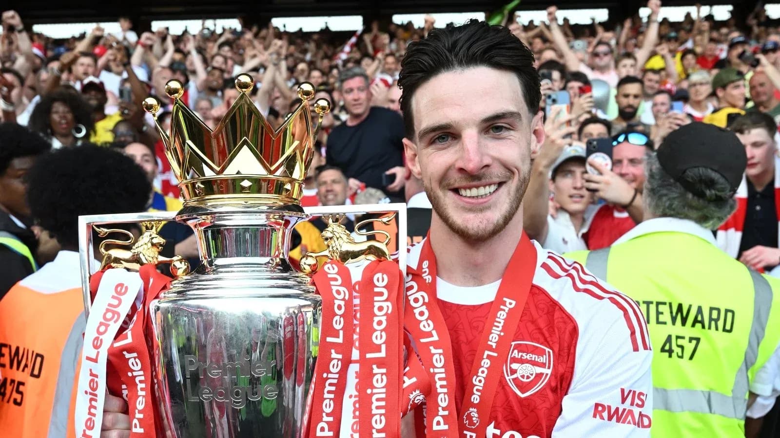 Player celebrating with Premier League trophy and fans