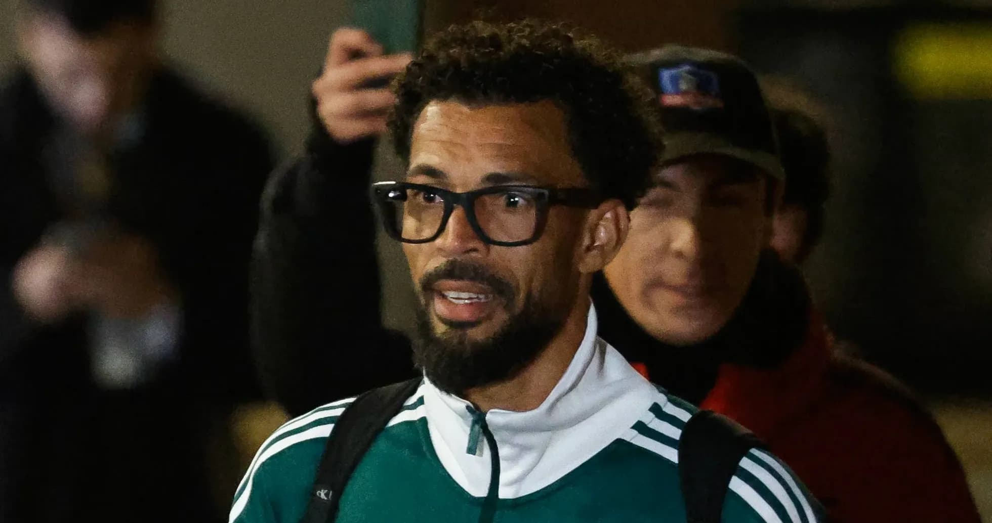 Player in green tracksuit arriving at venue
