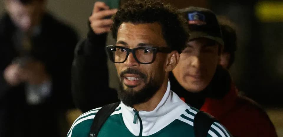 Player in green tracksuit arriving at venue