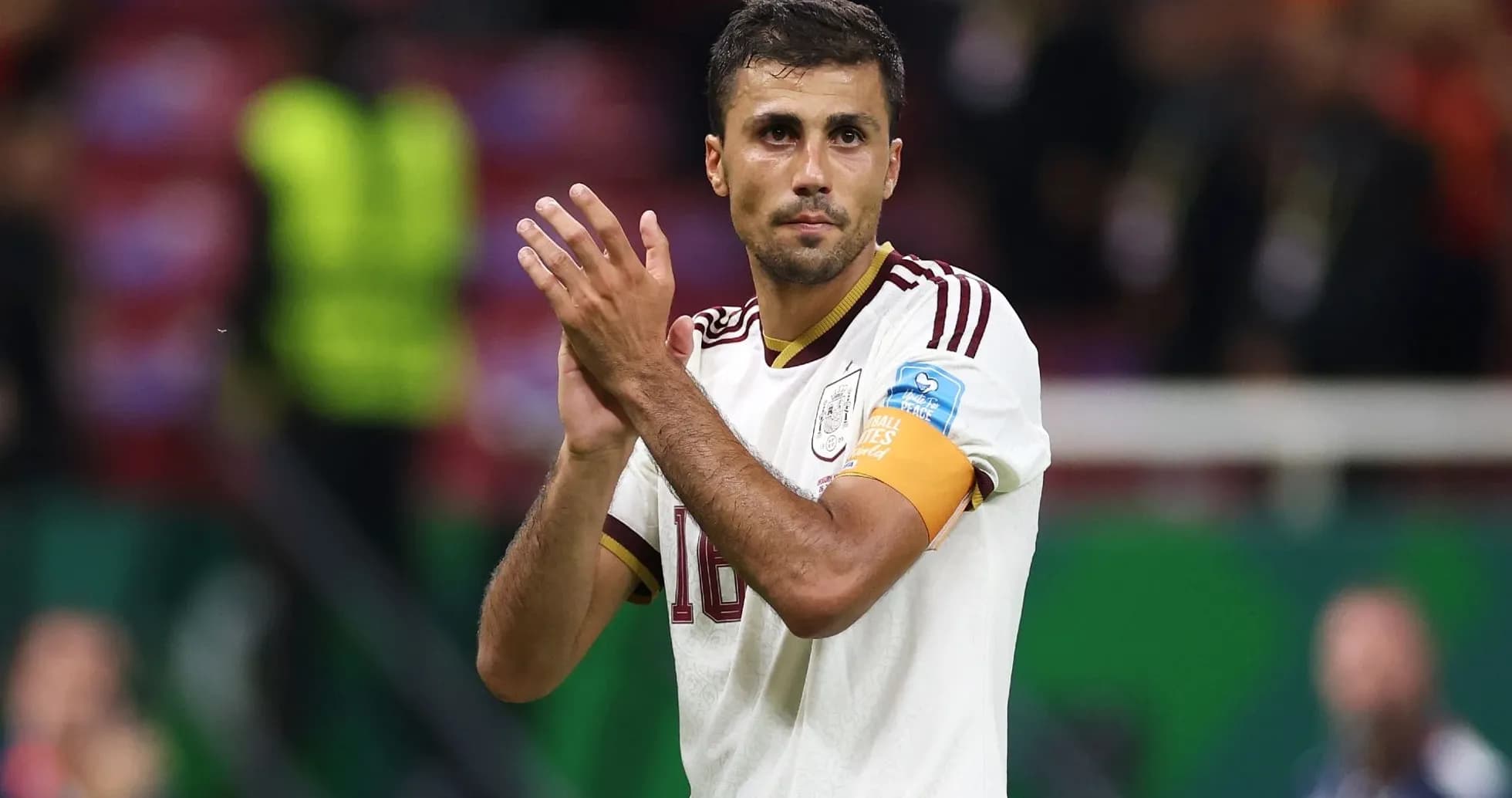 Player applauding fans after match wearing captain's armband
