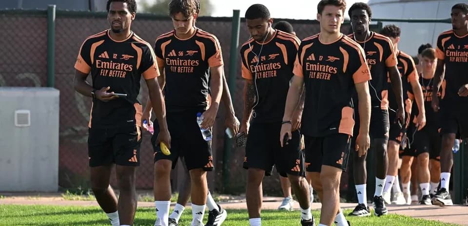 Arsenal players walking together in training kits