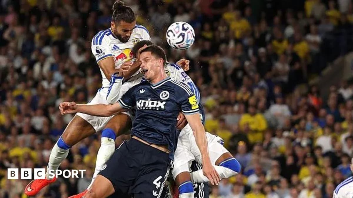 Players contesting a header during football match