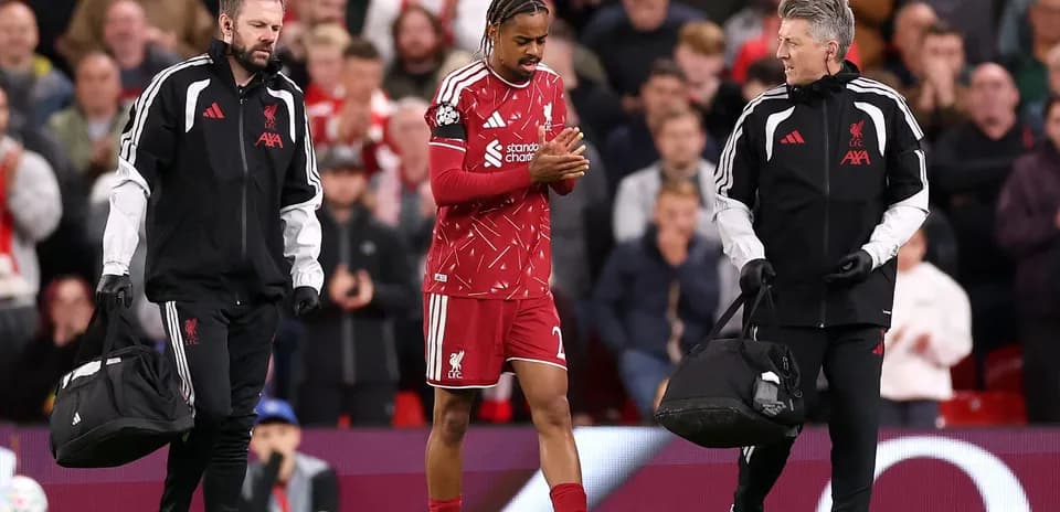 Liverpool player being assisted off the field by staff