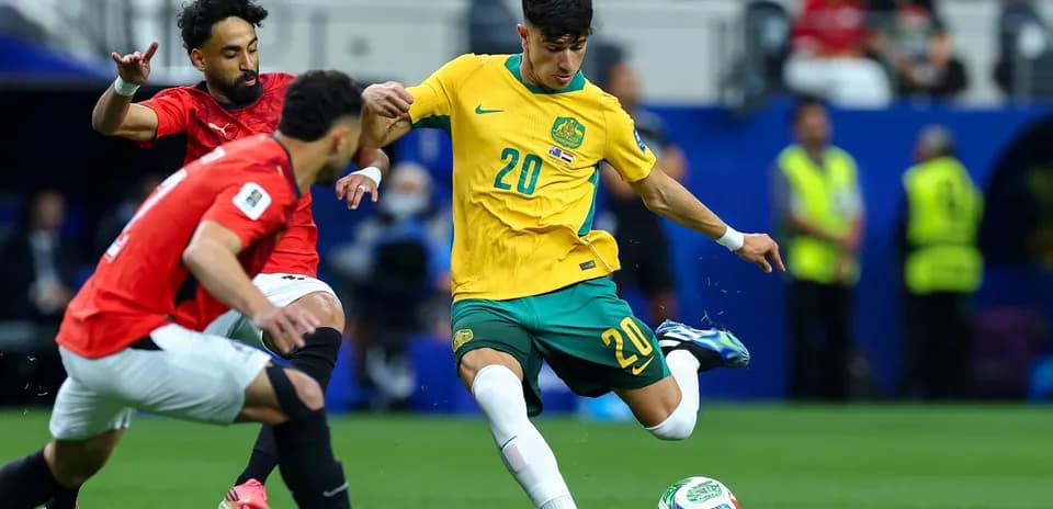 Australia player dribbling past Egyptian defenders
