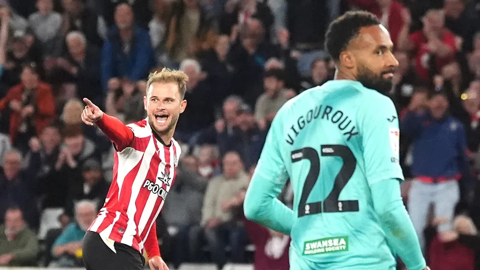Player celebrating a goal against opposing goalkeeper