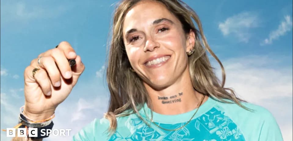 Athlete smiling and holding a pen outdoors