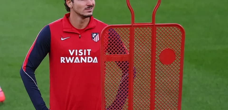 Player standing beside a training dummy on pitch