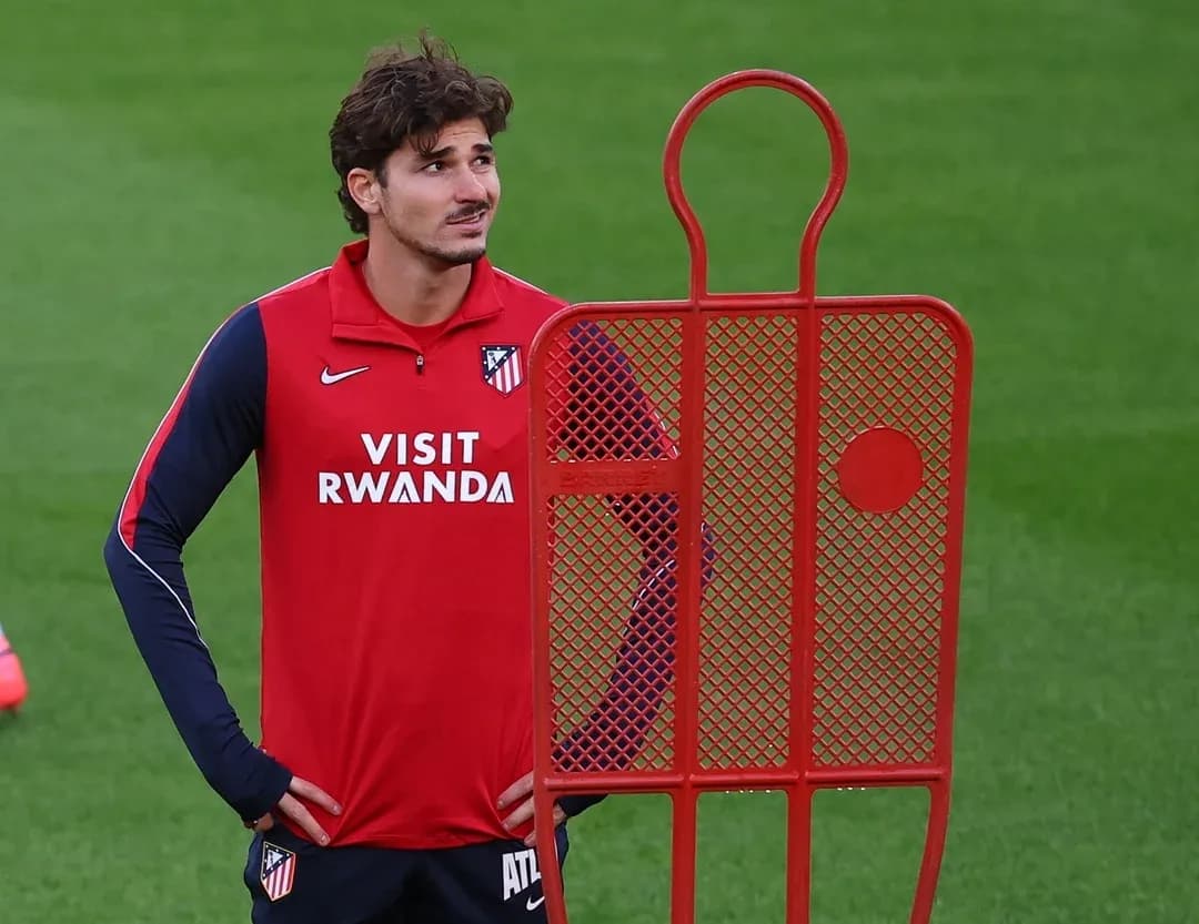 Player standing beside a training dummy on pitch