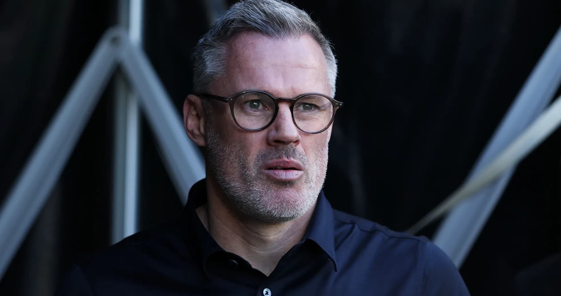 Man with glasses looking thoughtfully outdoors