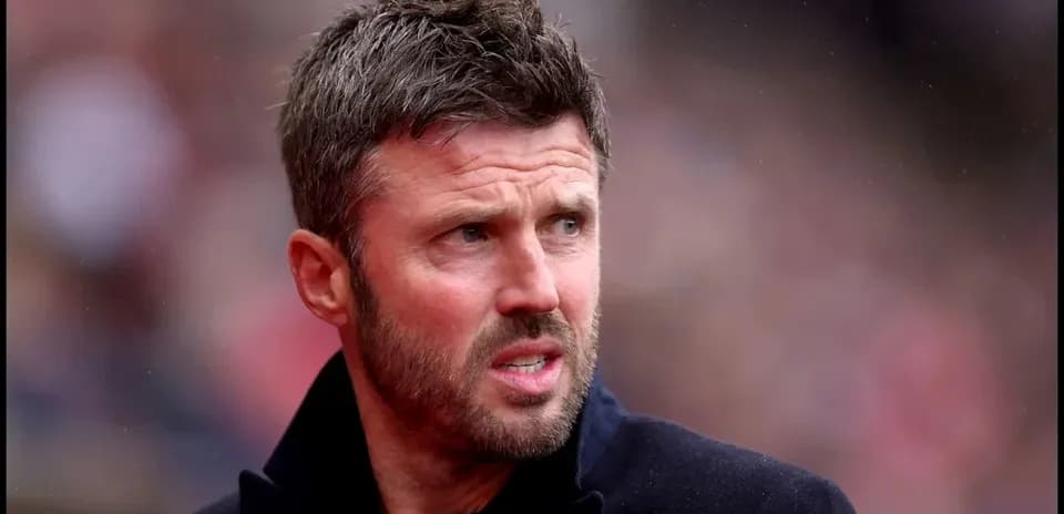 Man in black coat at a sports event