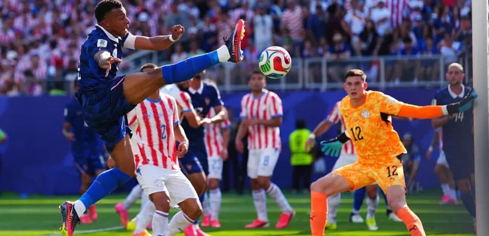 Player kicking ball during match with goalkeeper watching