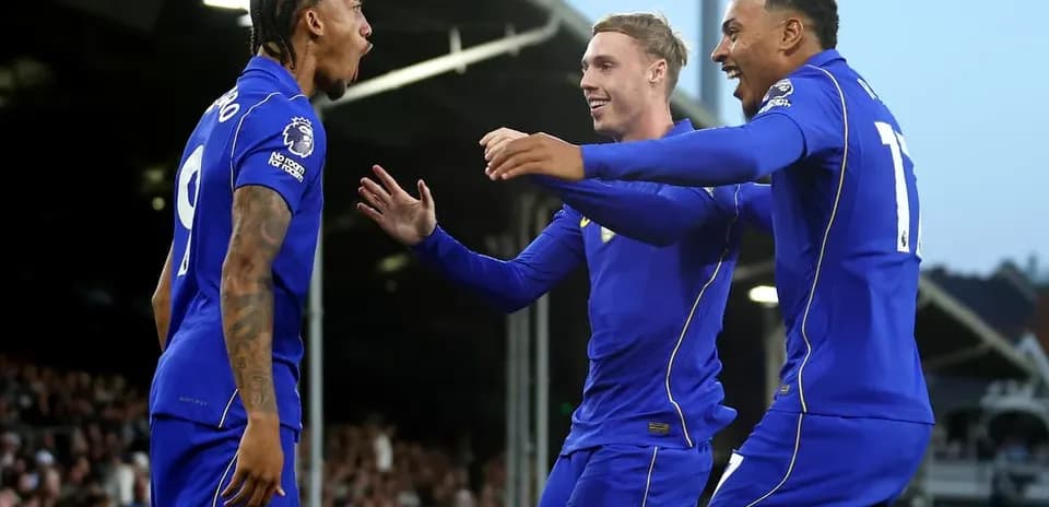 Three players celebrating a goal in blue jerseys