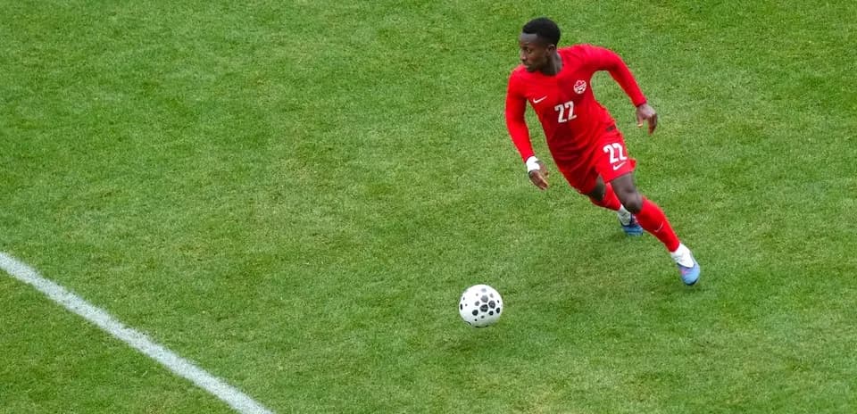 Player in red jersey running with the ball