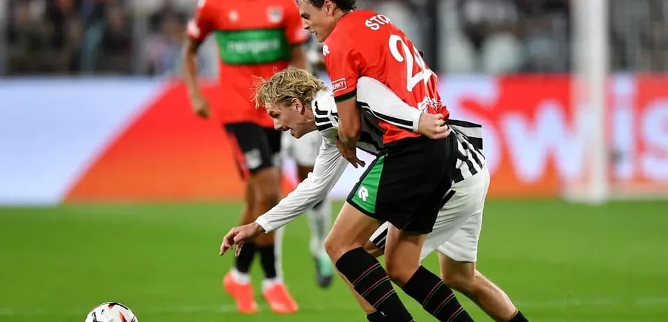 Two players battling for the ball on the field