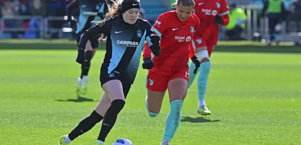 Players competing for the ball during NWSL match