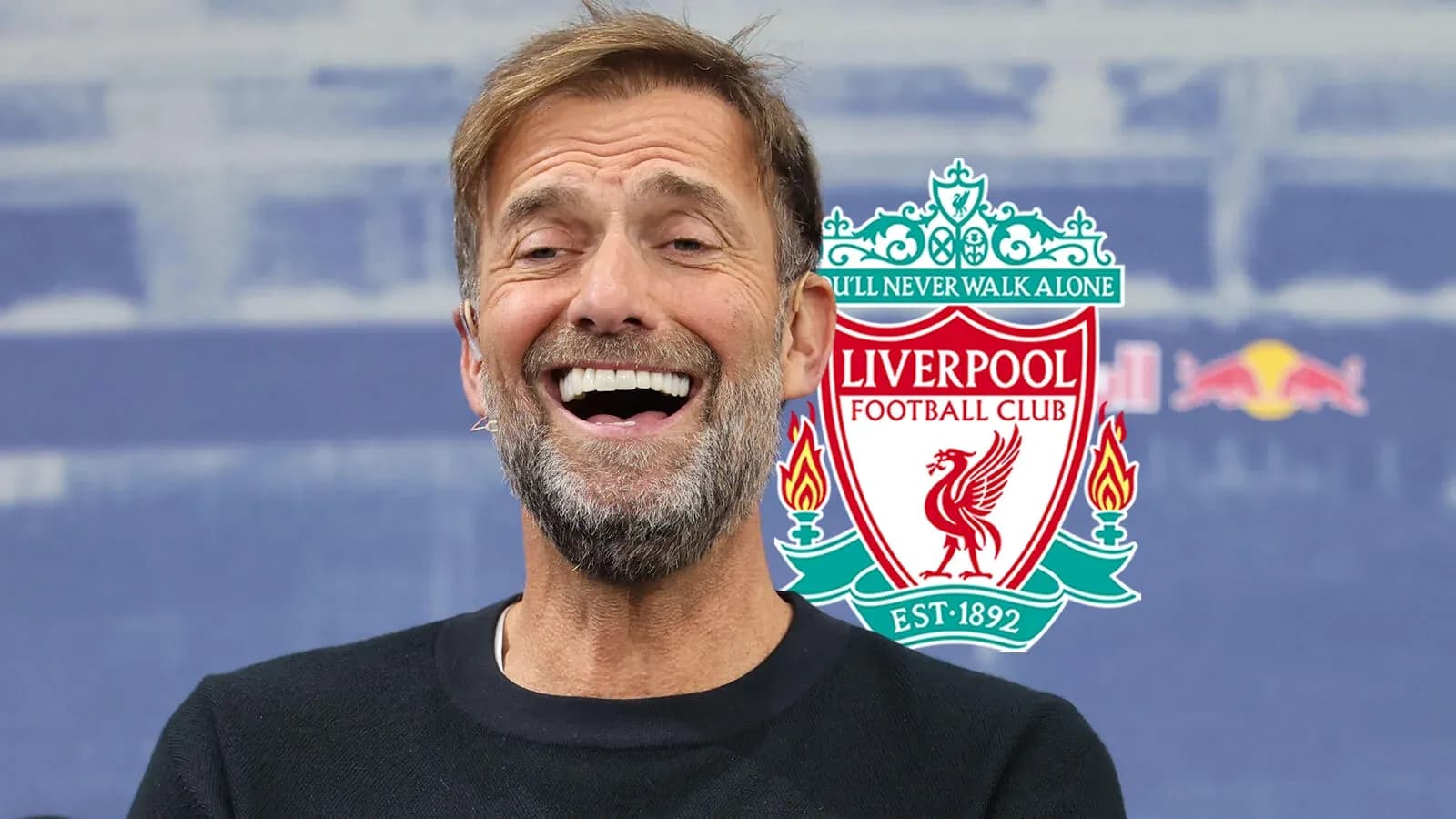Manager smiling during press conference with Liverpool logo