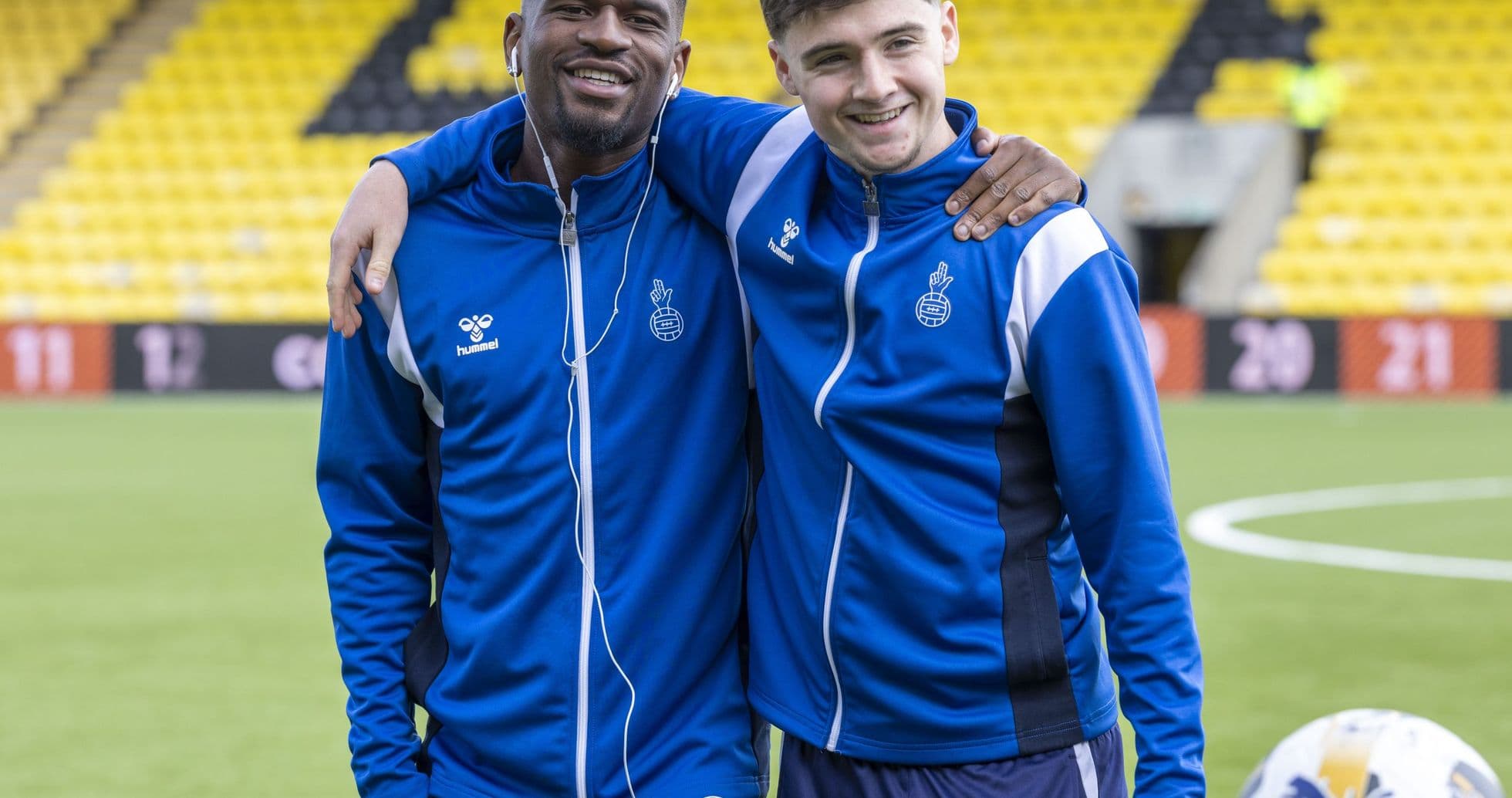 Two players posing together on the pitch