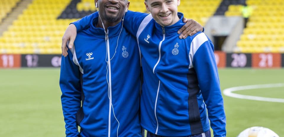 Two players posing together on the pitch