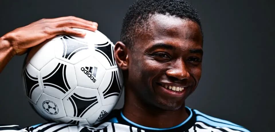 Player smiling while holding a soccer ball