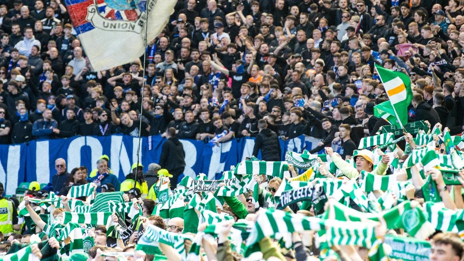 Fans waving green and white scarves in stadium