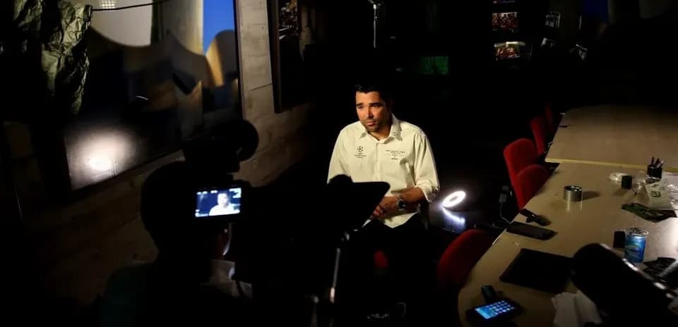 Person being interviewed in a dimly lit room