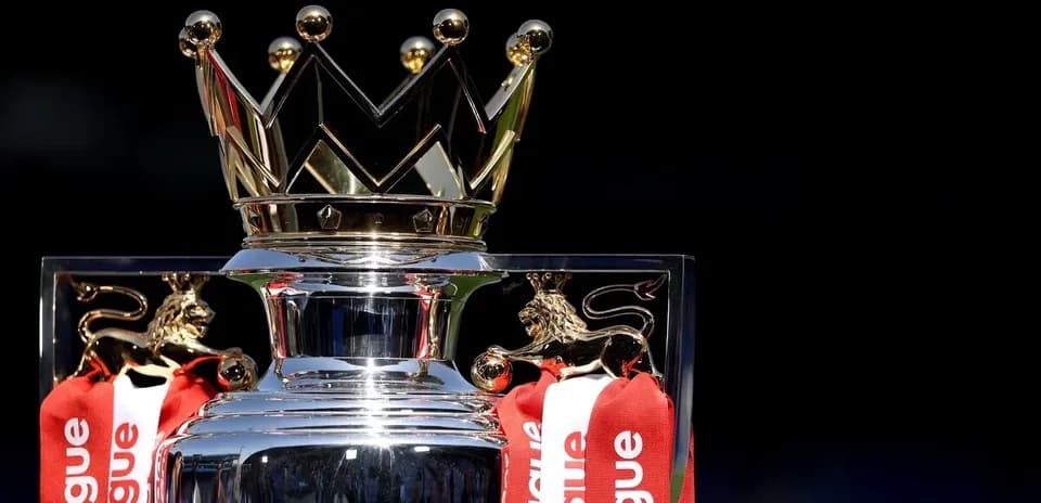 Premier League trophy with red ribbons on display