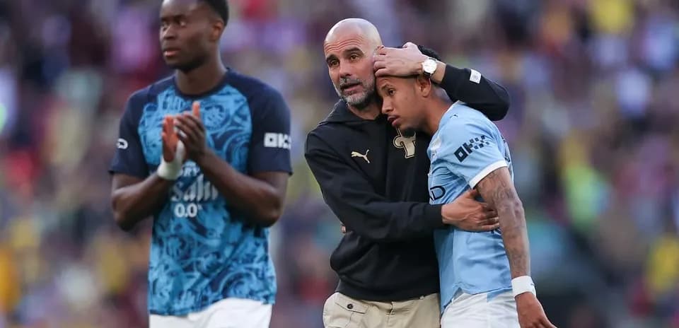 Coach comforting player after match, teammates nearby