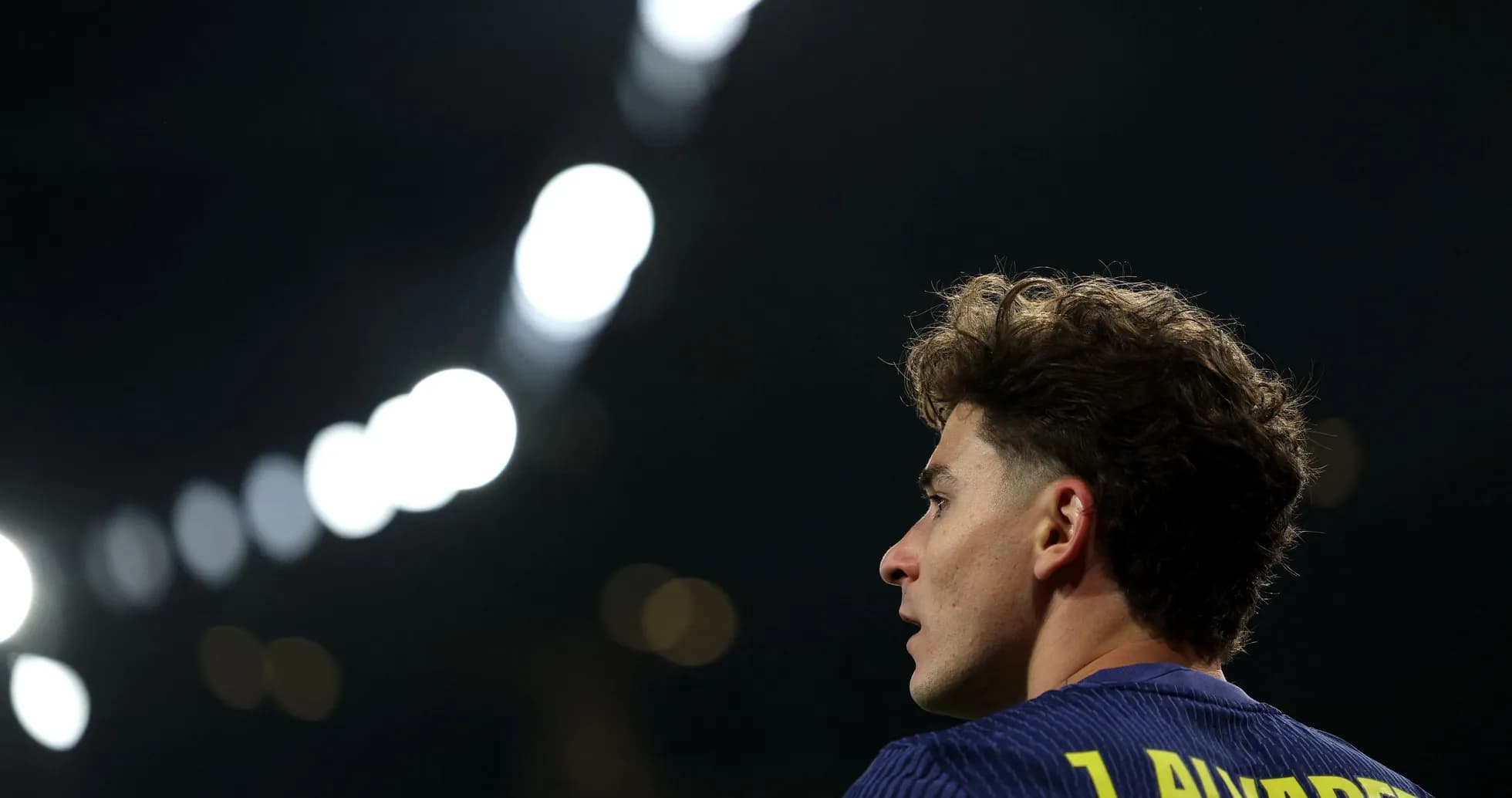 Player with curly hair in stadium lights