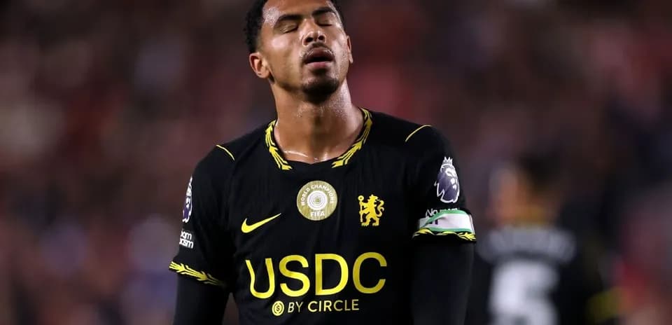 Player in black jersey looking disappointed on field