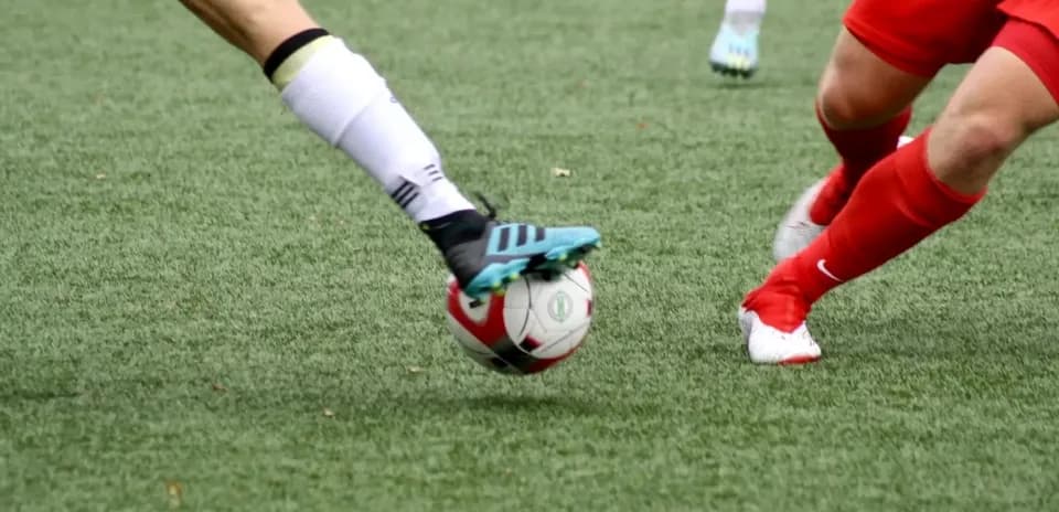Players competing for the ball in football match