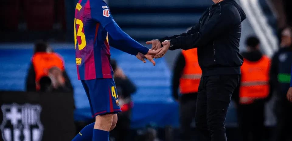 Player and coach shaking hands on the pitch