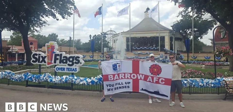 Fans holding Barrow AFC flag at Six Flags amusement park