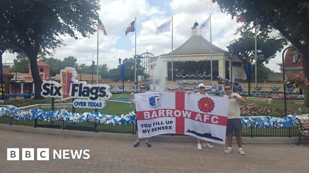 Fans holding Barrow AFC flag at Six Flags amusement park
