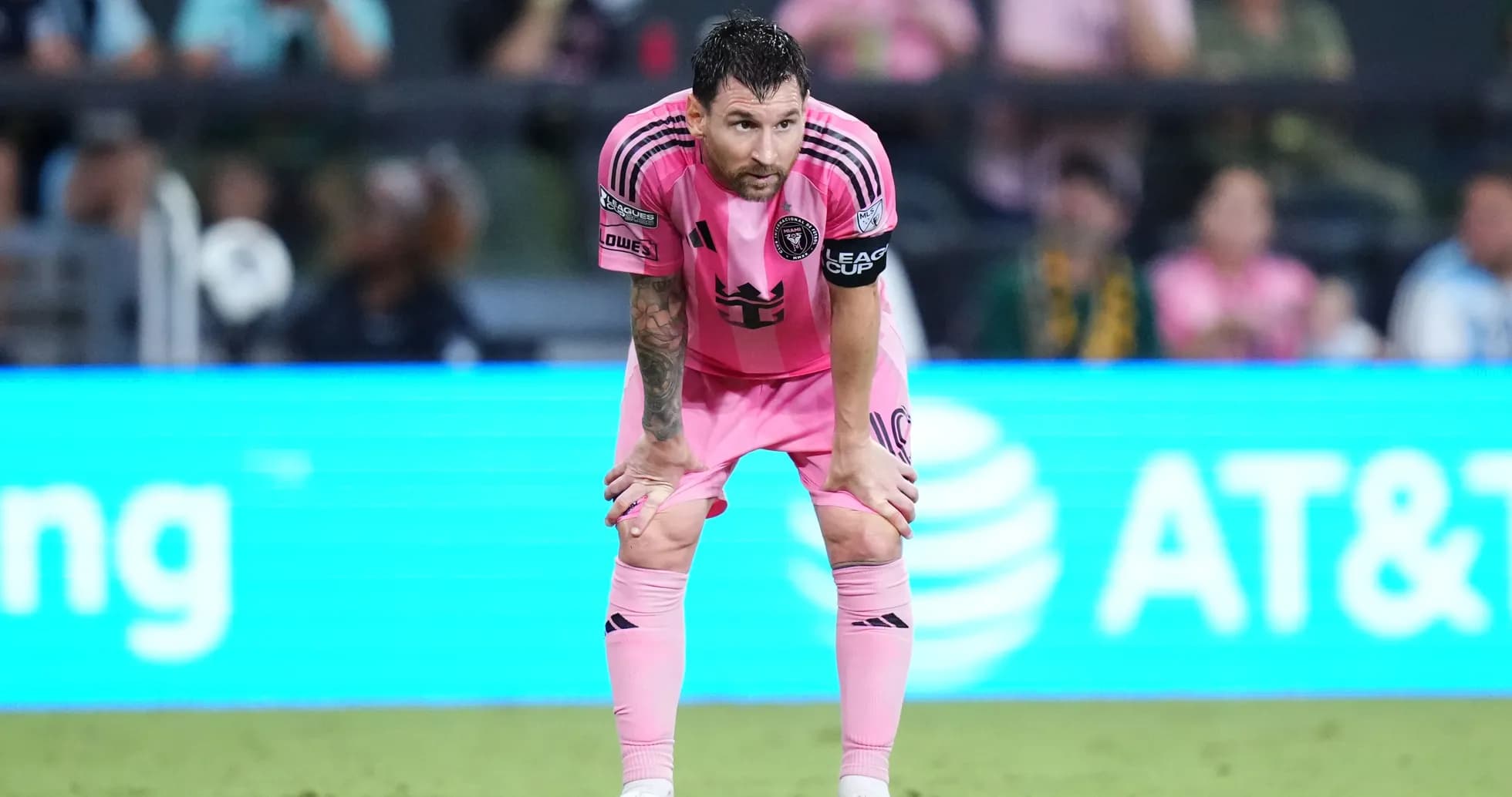 Player in pink jersey bent over on field